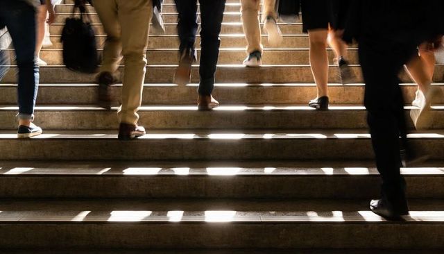 Sunlit Station Stairs with Commuters Ascending, Motion Blur Conveying Urban Rush Hour