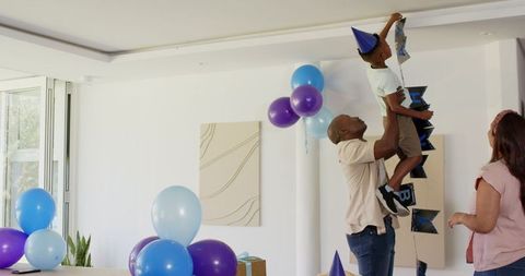 Diverse family celebrating birthday with joy and balloons