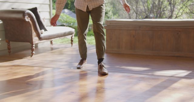 Person Walking in Sunlit Room with Wooden Floor - Download Free Stock Images Pikwizard.com