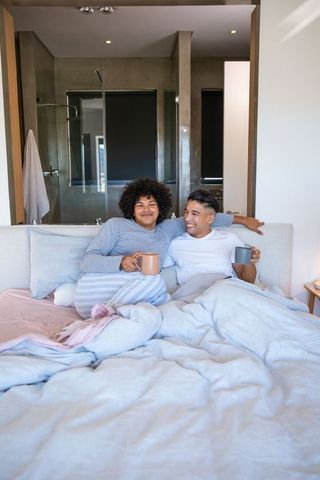 Cozy Couple Enjoying Morning Coffee in Bedroom