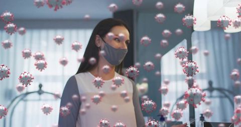 Masked guest using contactless card at hotel reception with floating virus particles