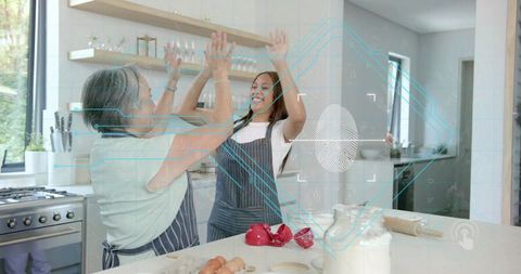 Mom and daughter high-fiving while baking on kitchen island with ar fingerprint overlay
