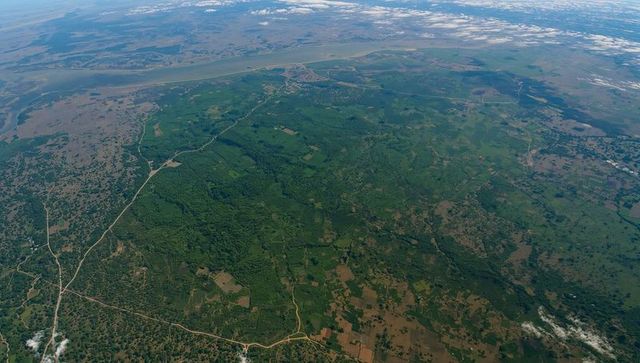 Aerial landscape of rural river basin with lush forest and fields