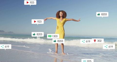 Joyful woman in yellow dress at beach with social media icons