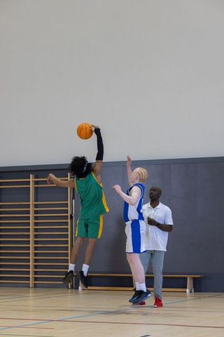 Diverse Male Basketball Players Practicing Shots in Gym