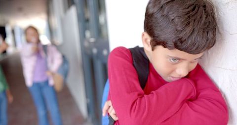 Sad Boy Leaning Against Wall in School being Bullied by Friends - Download Free Stock Images Pikwizard.com