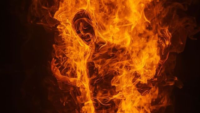 Fiery human silhouette in flame vortex