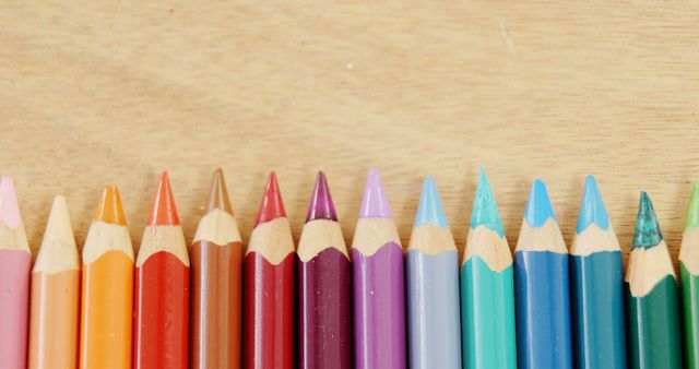Colorful pencils are arranged in a row on a wooden surface, with copy space - Download Free Stock Photos Pikwizard.com