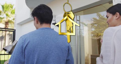 Excited couple moving into new home with gold key symbol