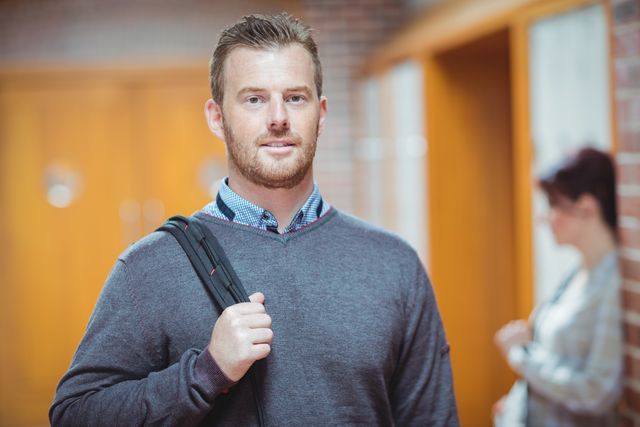 Mature student standing in a corridor with a backpack, looking confident. Ideal for use in educational materials, adult learning programs, university brochures, and professional development content.