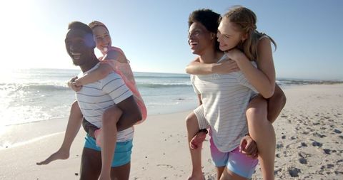Joyful Families Bonding with Piggyback Rides on Sunny Beach