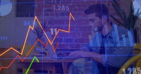 Young freelancer typing on laptop in cafe with financial charts overlay, analytics concept
