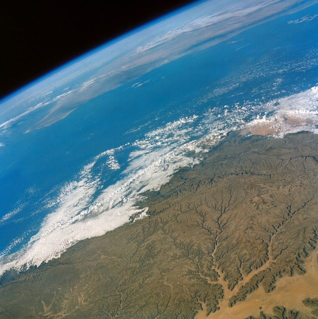 View of the Hahramaut Plateau in the southern Arabian Peninsula taken from Gemini-4 spacecraft in June 1965. Showcasing the dramatic landscape featuring the Wadi Hahramaut and the Gulf of Aden. Useful for educational materials on space exploration, geography lessons, climate studies, and promotional content related to NASA and space missions.