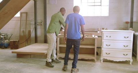 African american carpenters collaborating in woodworking studio