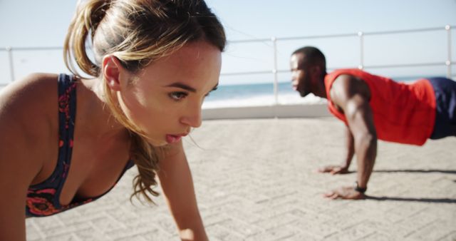 Focused Young Man and Woman Doing Push Ups on Beach - Download Free Stock Images Pikwizard.com