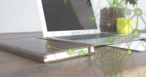 Silver laptop resting on leather folio showing green hexagonal finance network overlay