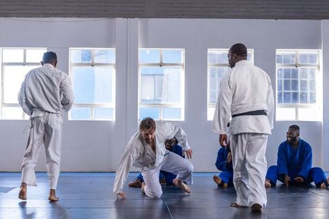 Diverse Group Practicing Judo Techniques in Dojo Environment