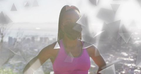 Backlit fitness woman wearing face mask and pink sports bra at urban overlook lens flare