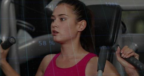 Focused young woman pressing chest press machine with futuristic digital fitness overlay