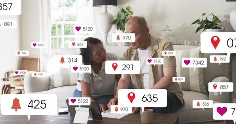 Mature couple reviewing bills and online accounts at home with floating notification icons