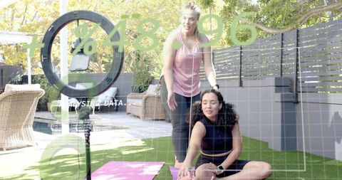 Female Personal Trainer Guiding Client Stretching Backyard Workout with Fitness Analytics