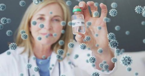 Female doctor holding covid-19 vaccine vial with virus overlays for healthcare research