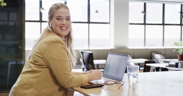 Smiling Businesswoman Working on Laptop in Modern Office Space - Download Free Stock Images Pikwizard.com