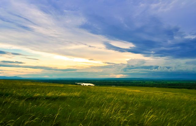 Vast Green Meadow Under Dynamic Sky at Sunset - Download Free Stock Photos Pikwizard.com