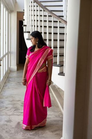 Elegant indian woman in vibrant pink saree in luxurious foyer