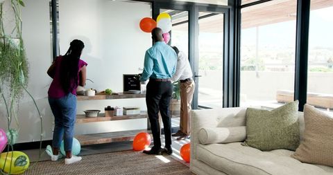 Colleagues Preparing Office with Balloons and Treats for Celebration