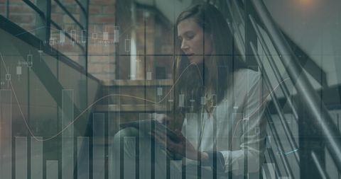 Caucasian businesswoman analyzing graphs on tablet in modern office