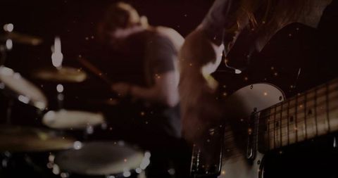 Bassist performing amidst dynamic stage lighting