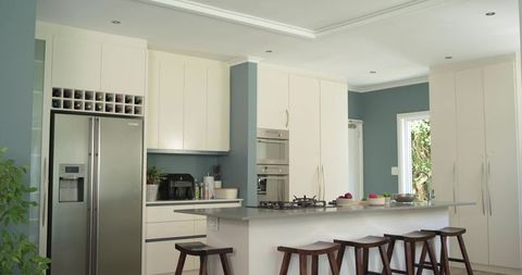 Contemporary open-plan kitchen featuring island with gray countertop and stainless refrigerator