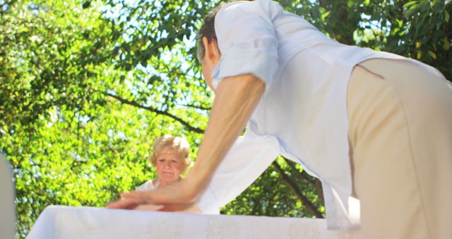 Senior man setting up outdoor table on sunny day - Download Free Stock Images Pikwizard.com