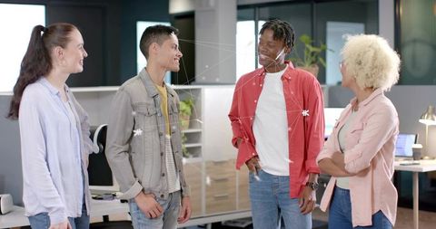 Diverse young team collaborating and networking in modern casual open-plan office workspace