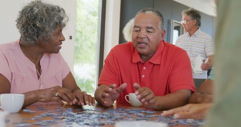 Senior citizens collaborating on a puzzle in retirement home