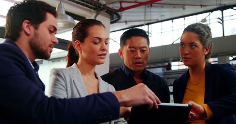 Business Leaders Collaborating Over Digital Technology in Modern Office Space