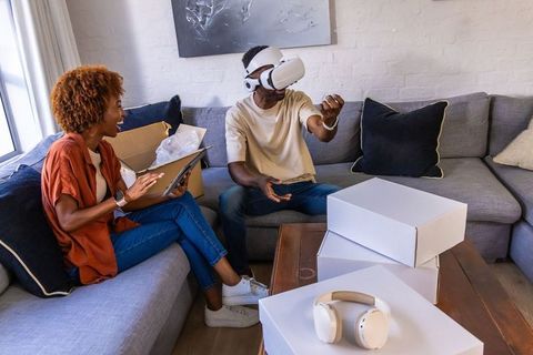African american couple exploring vr headset with tablet during home unboxing
