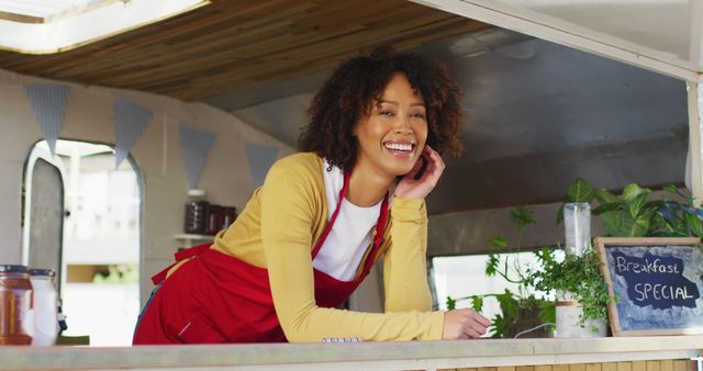 Portrait of african american woman wearing apron smiling while standing in the food truck - Download Free Stock Photos Pikwizard.com