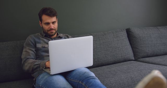 Young Man Working on Laptop on Comfortable Couch - Download Free Stock Images Pikwizard.com