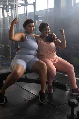 African american women celebrating strength and friendship while flexing together in gym