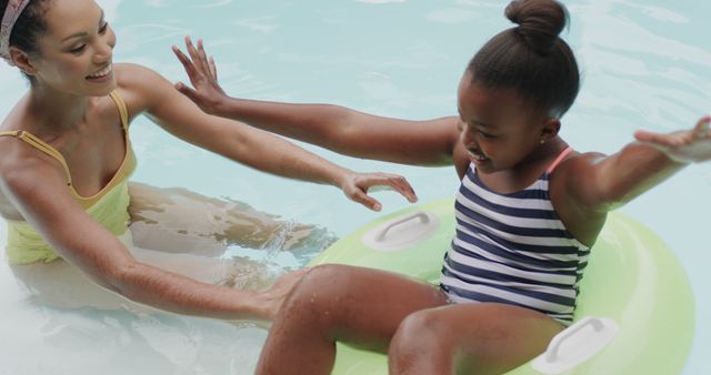 Mother Helping Daughter Enjoy Pool With Inflatable Tube - Download Free Stock Images Pikwizard.com