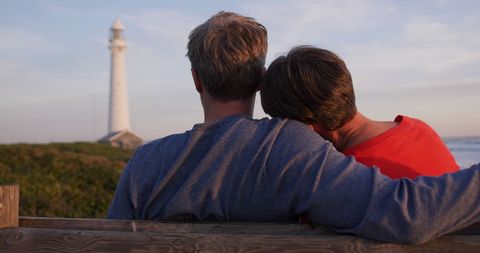 Senior Couple Embracing at Sunset by Lighthouse