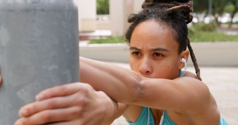 Focused African American Woman Exercising with Earphones Outdoors
