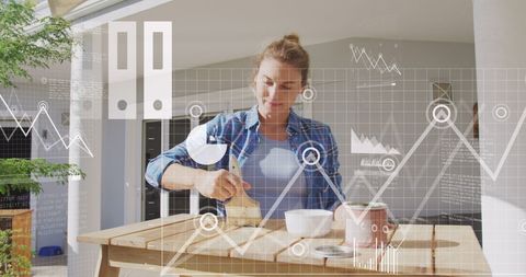 Woman Restoring Wooden Table with Digital Business Overlay
