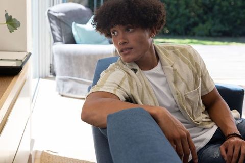 Man Relaxing on Armchair by Sunny Glass Door in Cozy Home Interior