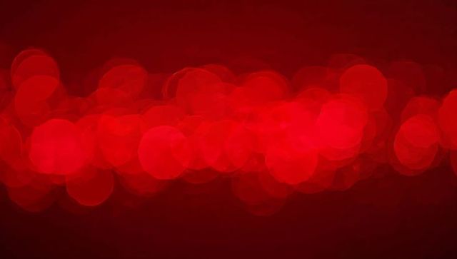 Glowing red bokeh band forming soft abstract circle lights for festive background