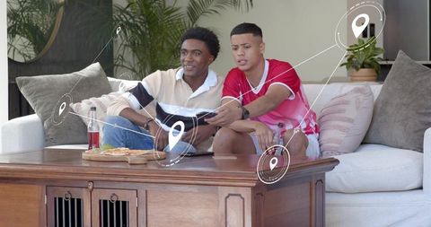 Young friends gaming on couch sharing pizza and drinks with digital location pins