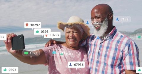 Senior couple taking selfie at beach with social media engagement overlays