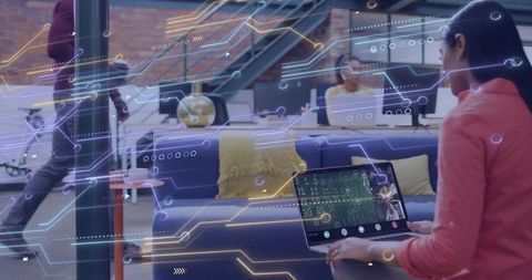 Developer coding on laptop in modern coworking space with augmented circuit overlay